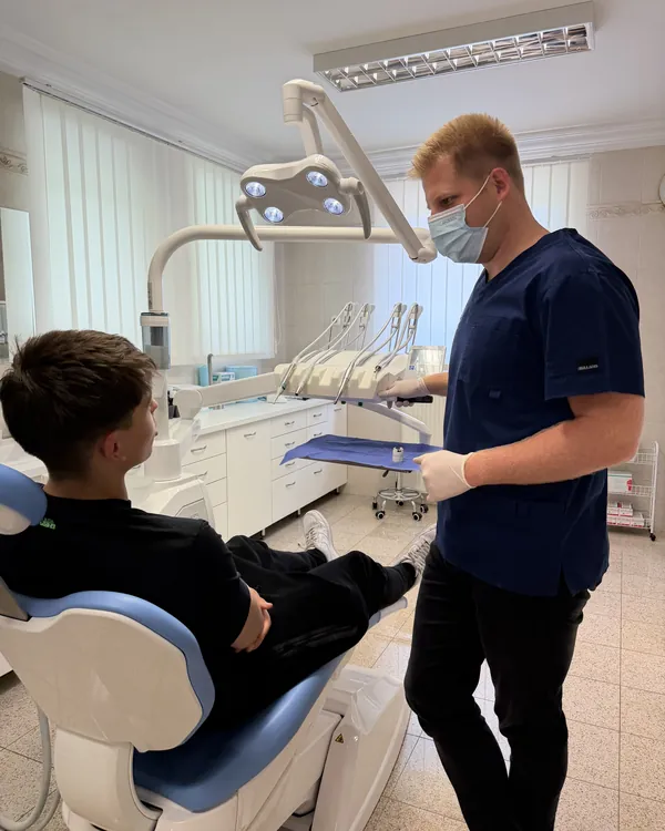 Dr. Gálffy Richárd a kezelőszékben ülő páciens mellett