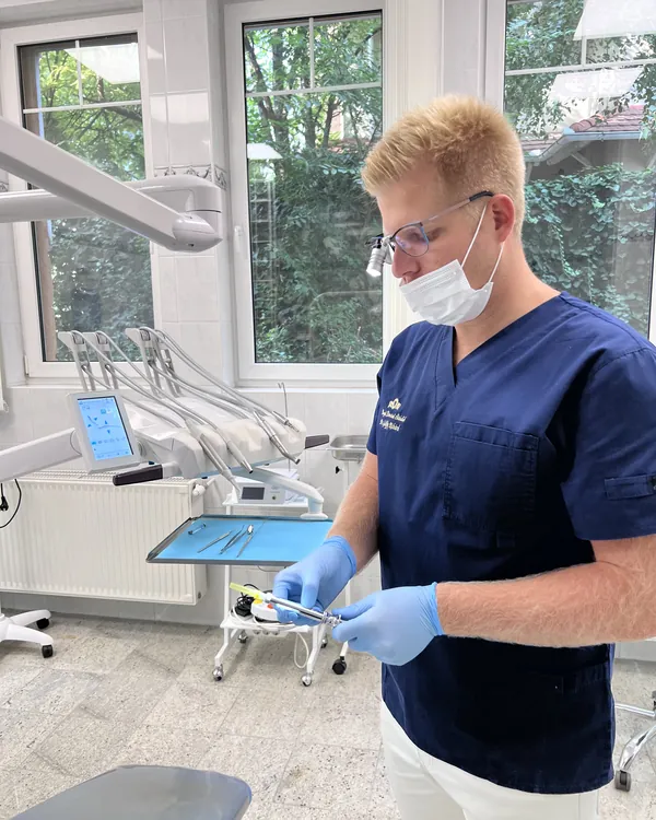 Dr. Gálffy Richárd nagyítószemüvegben, műszerrel a kezelőben